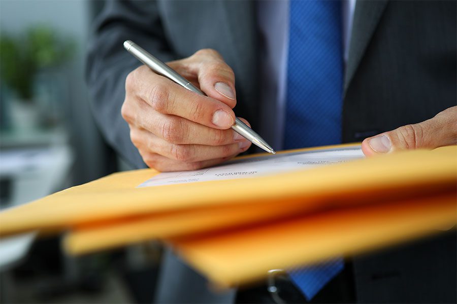 Bonds Applications - Closeup View of a Businessman Holding and Signing a Label on a Package