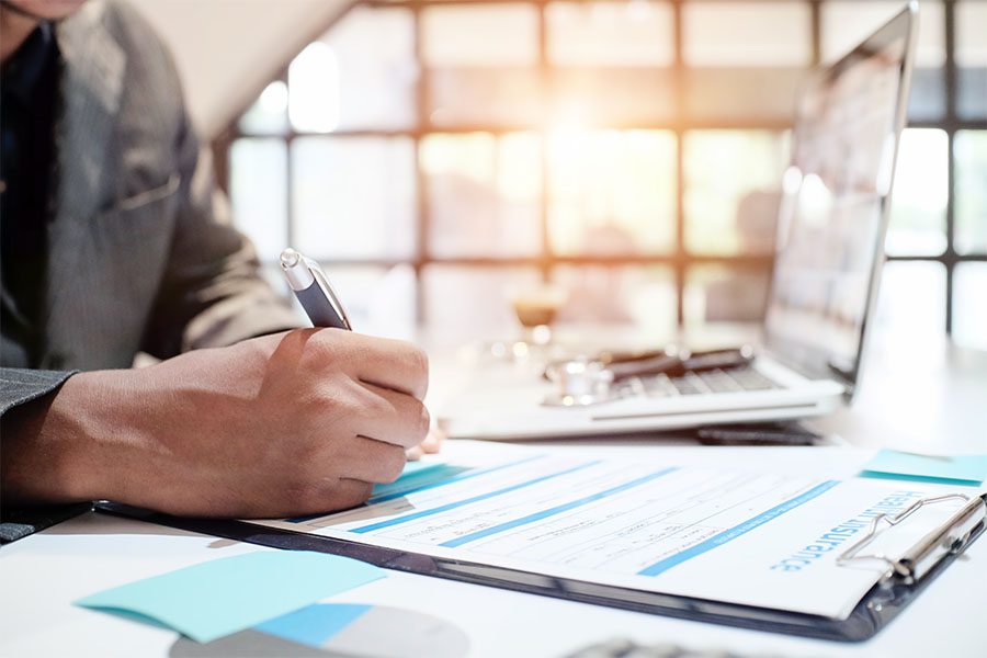 Insurance Applications - Closeup View of a Businessman Sitting in His Office While Working on Filling Out an Application