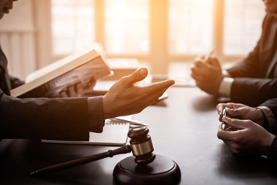 Judicial Bonds - View of a Group of Lawyers Sitting Around a Table Discussing a Case with Sunlight Coming Through the Windows